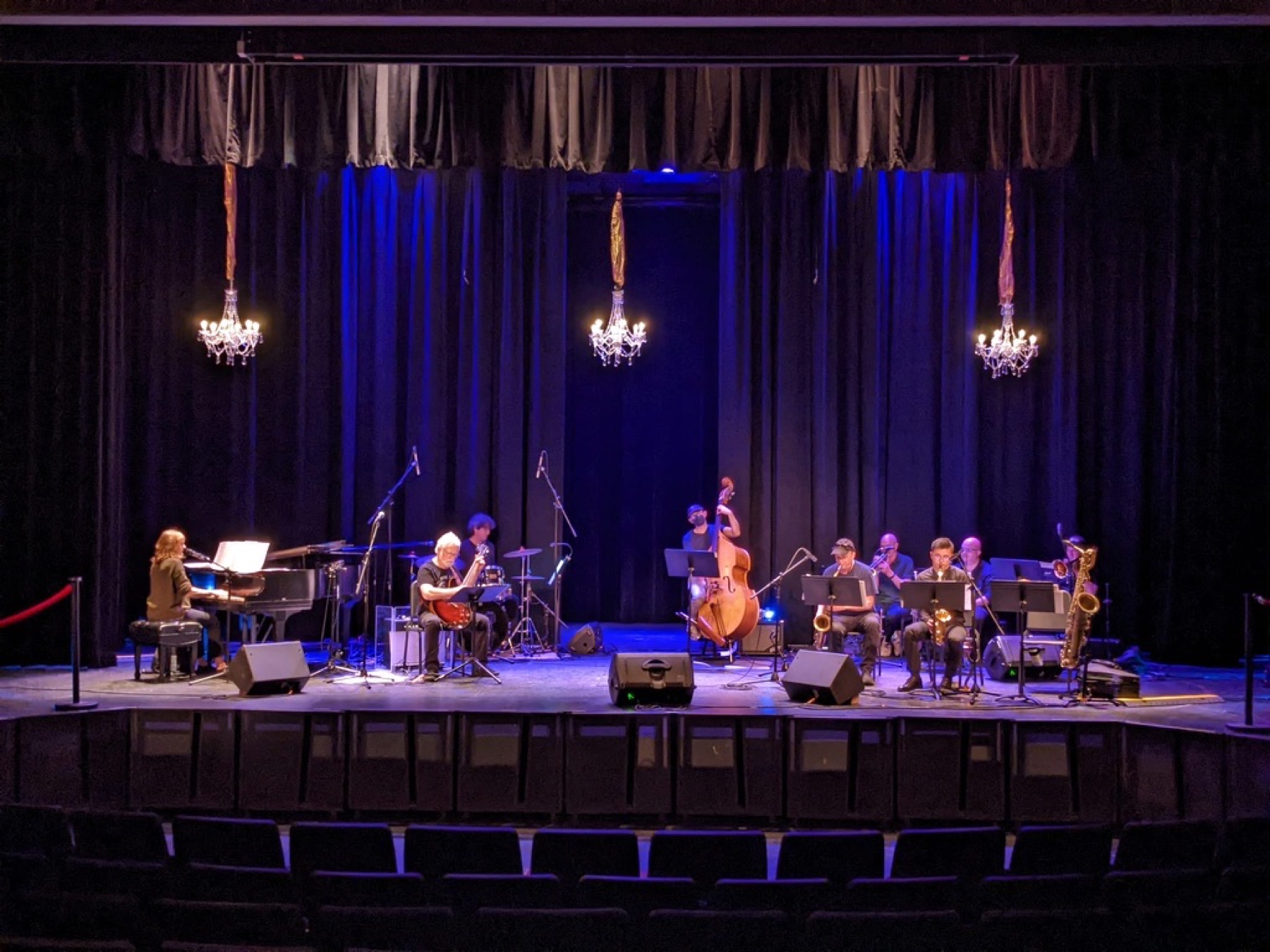 Jazz ensemble performing on stage under blue lighting