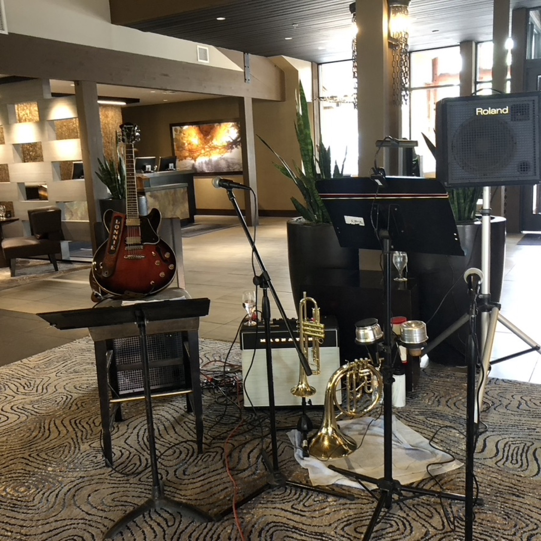 Performance setup with guitar, microphones, trumpet, and speakers